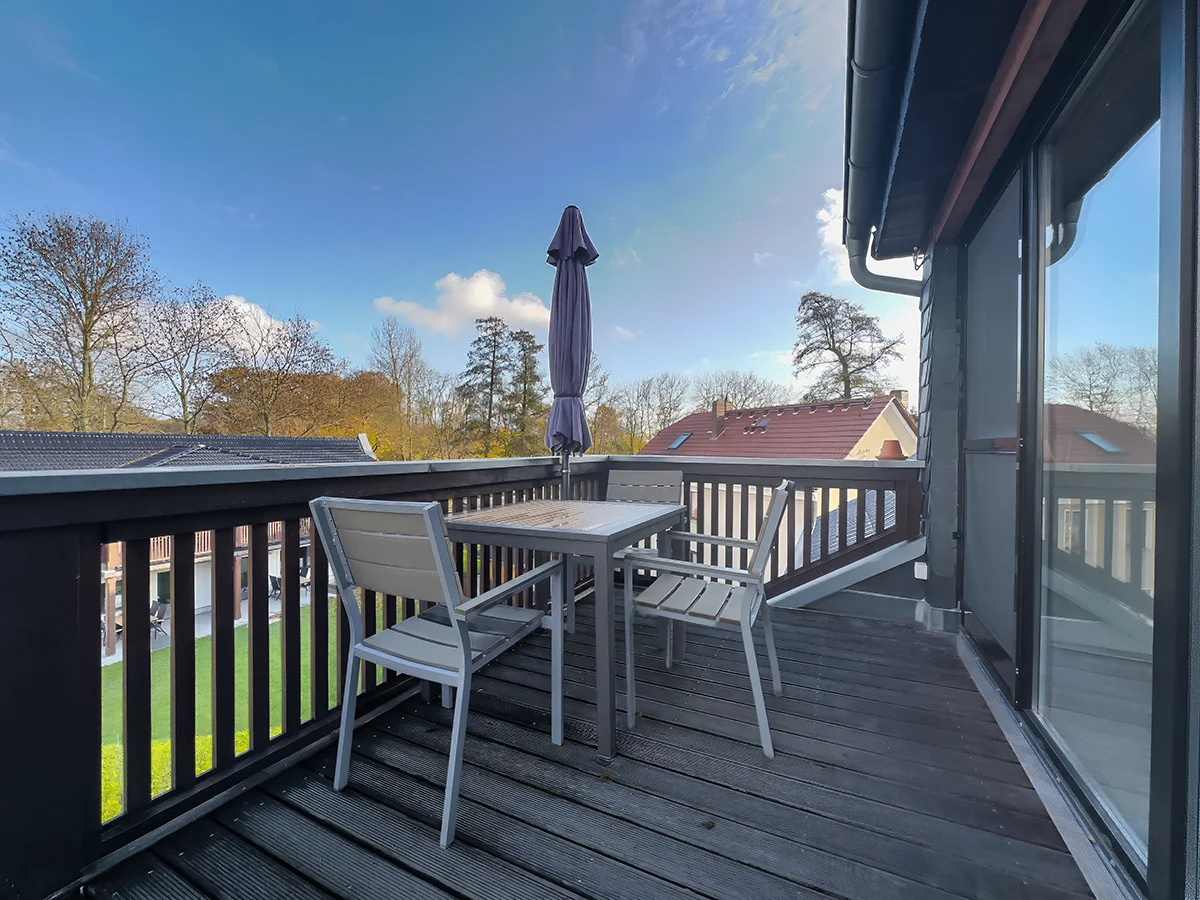 Sonniger Balkon der Ferienwohnung 6 mit grauer Sitzgruppe und Blick über die Dächer von Markkleeberg