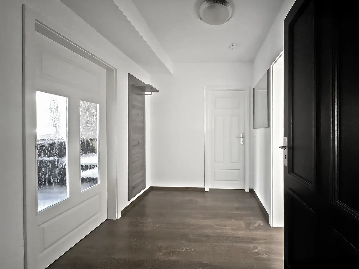 Eingangsbereich und Flur der Ferienwohnung 2 mit dunkler Tür und hellem Bodenbelag