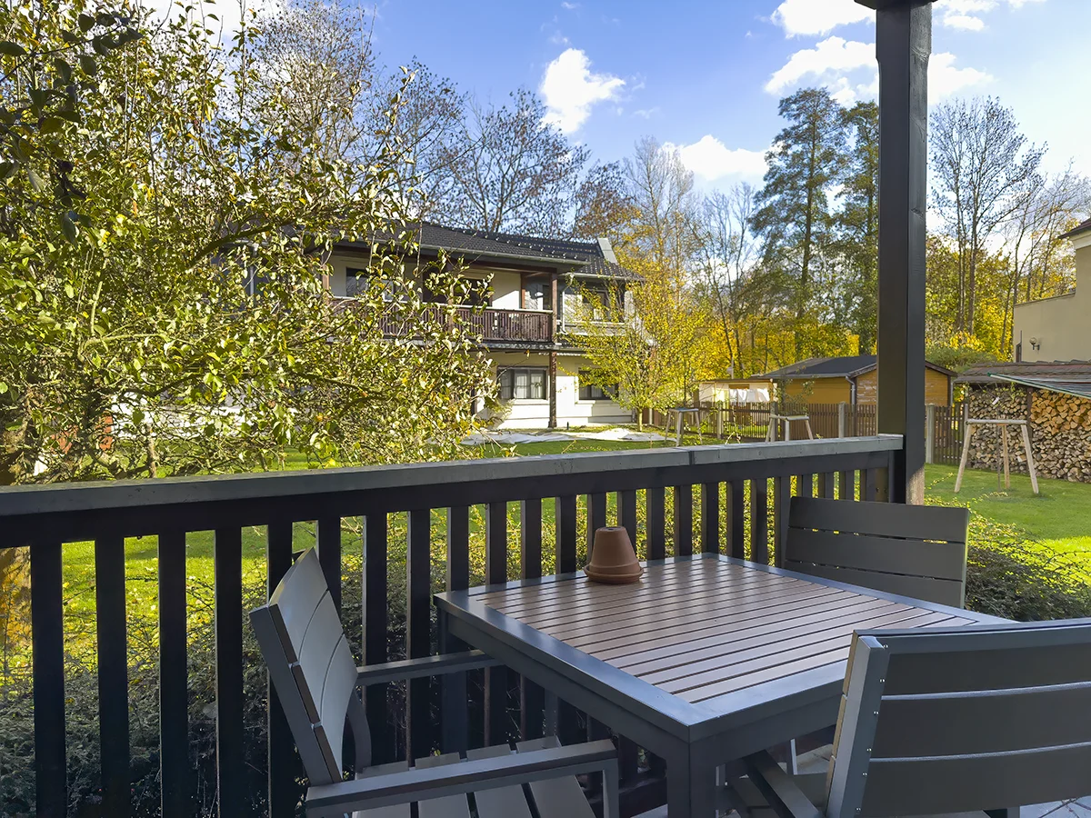 Möblierter Balkon der Ferienwohnung 2 im Obergeschoss mit Blick auf das begrünte Grundstück des Ferienhauses Kaiserhof