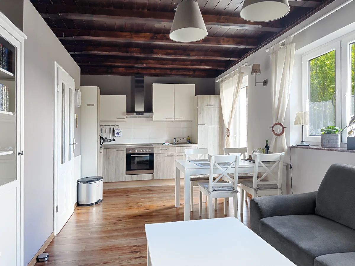 Offener Wohn- und Kochbereich der Ferienwohnung 4 mit vollausgestatteter Küchenzeile und Holzbalken.